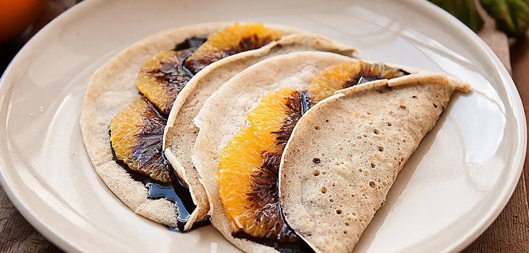 "Orange crêpes with chocolate sauce – a delightful citrus-infused dessert with a rich chocolate drizzle.