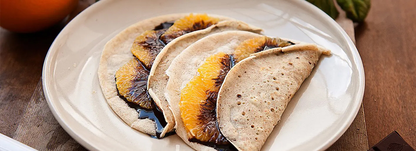 "Orange crêpes with chocolate sauce – a delightful citrus-infused dessert with a rich chocolate drizzle.