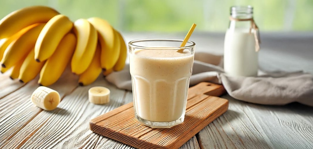 Creamy banana smoothie in a glass, garnished with fresh banana slices – a refreshing and nutritious drink idea.