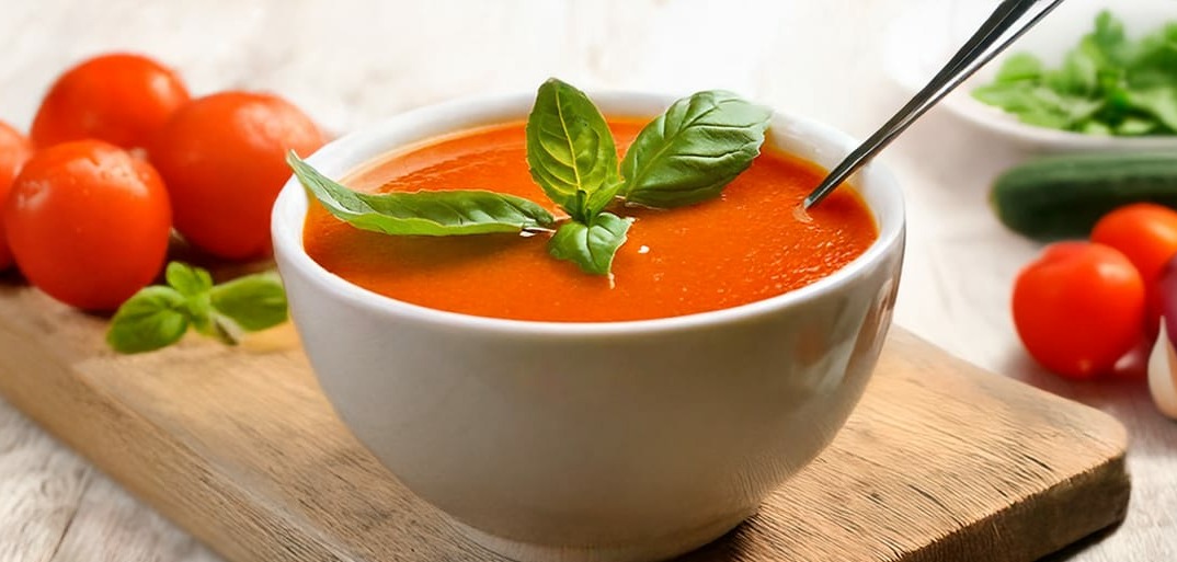 Refreshing gazpacho soup made with fresh tomatoes, cucumbers, and peppers, served chilled and garnished with herbs