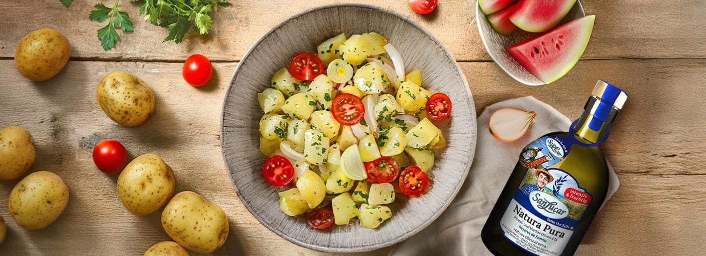 Action_olive_oil_and_plant_BBQ_promotion _Header Potato salad with cherry tomatoes, onions, and herbs served with SanLucar Natura Pura olive oil
