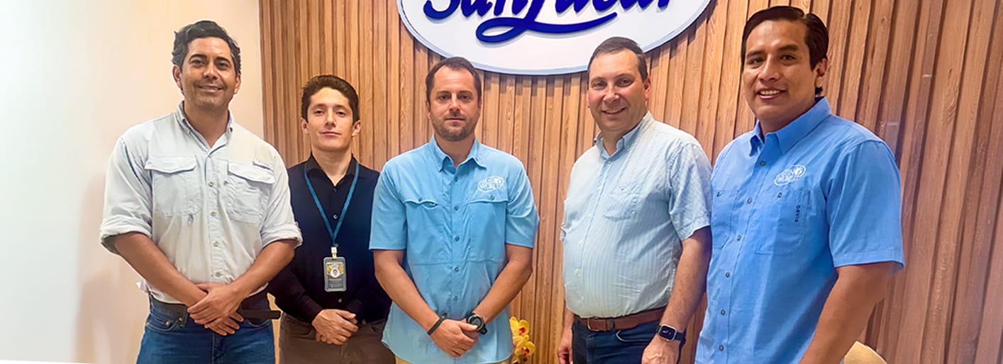 Sun_World_Header SanLucar team members standing together at company office in front of branded logo wall